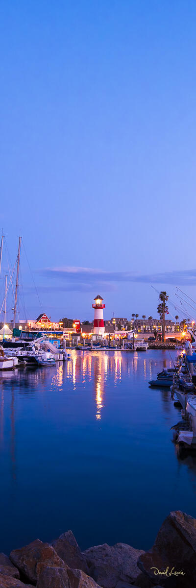 Oceanside Harbor Early Morning Vertical early morning photograph of Oceanside Harbor with calm blue water, boats, reflections, and the distant lighthouse.
